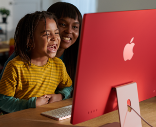 Drie gezinsleden lachen om een serie die ze op iMac bekijken.