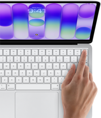 MacBook Neo, kleur Zilver, inlogscherm, iemand drukt met een vinger op de Touch ID-sensor in de rechterbovenhoek van het toetsenbord